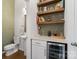 Chic bar area with custom shelves, countertop, and wine cooler, perfect for entertaining at 9914 Ainslie Downs St, Charlotte, NC 28273
