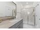 Modern bathroom with neutral tones, a glass-enclosed shower, and a vanity with stone countertops at 9914 Ainslie Downs St, Charlotte, NC 28273