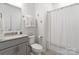 Clean bathroom featuring a single sink vanity, white walls, neutral finishes and a shower curtain at 9914 Ainslie Downs St, Charlotte, NC 28273
