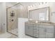 Bathroom featuring a glass-enclosed shower with marble-like tiling and a double vanity with neutral countertops at 9914 Ainslie Downs St, Charlotte, NC 28273