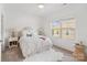 Sunlit bedroom with neutral decor, white bedding, a side table, and a window overlooking the neighborhood at 9914 Ainslie Downs St, Charlotte, NC 28273