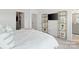 Bright bedroom with a walk-in closet, a TV on the wall, and shelving units for storage and display at 9914 Ainslie Downs St, Charlotte, NC 28273