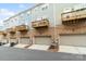 Modern townhome row featuring private garages and small wooden balconies on the upper floors at 9914 Ainslie Downs St, Charlotte, NC 28273