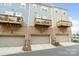 Townhome garages with brick facade and small balconies overhead, adding a touch of charm and functionality at 9914 Ainslie Downs St, Charlotte, NC 28273