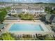 Aerial view of a community pool surrounded by townhomes, lounge chairs, and landscaping at 9914 Ainslie Downs St, Charlotte, NC 28273