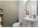 Stylish powder room features a pedestal sink, modern fixtures, and subtle accent wall at 9914 Ainslie Downs St, Charlotte, NC 28273