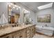 Bright bathroom featuring double vanity, soaking tub, skylight and updated fixtures at 10315 Washam Potts Rd, Cornelius, NC 28031