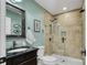 Tiled bathroom featuring a glass enclosed shower, modern vanity, and decorative mirror at 10315 Washam Potts Rd, Cornelius, NC 28031