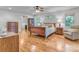 Bedroom with hardwood floors, bright windows, ceiling fan, and warm lighting at 10315 Washam Potts Rd, Cornelius, NC 28031