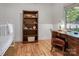 Bedroom with hardwood floors, crib, desk, chair and bookcase by a bright window at 10315 Washam Potts Rd, Cornelius, NC 28031