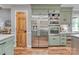 Kitchen with stainless steel refrigerator, oven, modern cabinets and hardwood floors at 10315 Washam Potts Rd, Cornelius, NC 28031