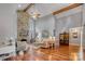 Open living room boasts a soaring ceiling with wooden beams, stone fireplace, and hardwood floors at 10315 Washam Potts Rd, Cornelius, NC 28031