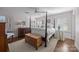 Bright main bedroom features a four poster bed, hardwood floors, and natural light through shuttered windows at 106 N Turner Ave, Charlotte, NC 28216