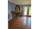 Living room with hardwood floors, fireplace with decorative stone work, and glass patio doors, creating a cozy living space at 1110 Hollyberry Ln, Salisbury, NC 28147