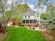 Expansive backyard featuring a screened porch, brick patio with seating, and lush green lawn at 1176 Fawn Ridge Nw Rd, Concord, NC 28027