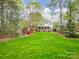 Well maintained backyard with lush lawn, mature trees, and a charming patio area at 1176 Fawn Ridge Nw Rd, Concord, NC 28027