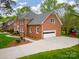 Stately two-story brick home with a two-car garage, manicured lawn, and mature trees offers classic curb appeal at 1176 Fawn Ridge Nw Rd, Concord, NC 28027