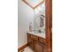 A half bath with wood vanity, countertop, mirror, and light at 1176 Fawn Ridge Nw Rd, Concord, NC 28027
