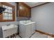 A laundry room with a utility sink and washer and dryer with cabinets above at 1176 Fawn Ridge Nw Rd, Concord, NC 28027
