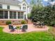 Inviting brick patio with comfortable seating area, fire pit, and a view of the landscaped yard at 1176 Fawn Ridge Nw Rd, Concord, NC 28027
