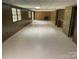 Large basement featuring brick fireplace, paneled walls and tiled flooring at 1199 Riding Trail Ln, Concord, NC 28027