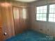 Bedroom featuring wood paneling, carpeted floor, closet and natural light at 1199 Riding Trail Ln, Concord, NC 28027