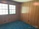 Cozy bedroom with wood paneling, carpeted floor, and natural lighting at 1199 Riding Trail Ln, Concord, NC 28027