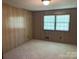 Bedroom with wood paneled walls, wall to wall carpet and a window at 1199 Riding Trail Ln, Concord, NC 28027