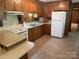 Cozy kitchen boasts wooden cabinets, white appliances, and a tile floor at 1199 Riding Trail Ln, Concord, NC 28027