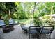 Outdoor patio area with comfortable seating and a fire pit, surrounded by lush greenery at 1201 Robinhood Cir, Charlotte, NC 28227