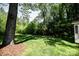 Lush backyard with mature trees and a peek at the outbuilding for added appeal at 1201 Robinhood Cir, Charlotte, NC 28227