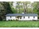 Charming single-story white home featuring a well-manicured lawn and inviting curb appeal at 1201 Robinhood Cir, Charlotte, NC 28227