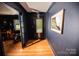Hallway with dark blue walls, hardwood floors, and an exterior door at 1201 Robinhood Cir, Charlotte, NC 28227