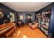 Cozy living room featuring hardwood floors, built-in bookshelves, and a vintage piano at 1201 Robinhood Cir, Charlotte, NC 28227