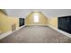 Attic space with carpet, yellow accent wall, and natural light at 12932 Westmoreland Farm Rd, Davidson, NC 28036