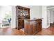 Custom wooden bar with glass storage and counter space, open to other living area spaces at 12932 Westmoreland Farm Rd, Davidson, NC 28036