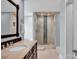 Well-lit bathroom with a tile shower, vanity with sink, and tiled floor at 12932 Westmoreland Farm Rd, Davidson, NC 28036