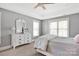 Comfortable bedroom with neutral tones, large windows, and a ceiling fan at 12932 Westmoreland Farm Rd, Davidson, NC 28036