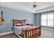 Cozy bedroom features a wood frame bed, ceiling fan, and natural light at 12932 Westmoreland Farm Rd, Davidson, NC 28036