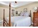 Bedroom features four-poster bed, side tables, and ensuite bathroom access at 12932 Westmoreland Farm Rd, Davidson, NC 28036