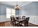 Bright dining room with chair rail molding, an elegant chandelier, and natural light at 12932 Westmoreland Farm Rd, Davidson, NC 28036