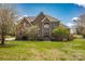 Elegant brick home featuring a well-manicured lawn, mature trees, and a grand entrance at 12932 Westmoreland Farm Rd, Davidson, NC 28036