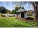 Charming outbuilding with a covered porch and a white picket fence creating a picturesque backyard scene at 12932 Westmoreland Farm Rd, Davidson, NC 28036