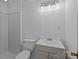 Well-lit bathroom featuring a white vanity, toilet, and a shower with glass doors at 1315 Arbor Dr, Salisbury, NC 28144