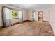 Spacious living room with neutral carpet, large windows, and hardwood trim details at 1315 Arbor Dr, Salisbury, NC 28144