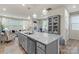 Granite kitchen island overlooking an open-concept living area with hardwood floors and stylish lighting at 1354 Galloway Rd, Charlotte, NC 28262