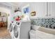 Well-lit laundry room with modern washer and dryer, plus stylish decor at 13924 Island Dr, Huntersville, NC 28078