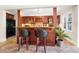 Wet bar in basement with dark wood cabinets, granite countertops, and barstool seating at 1404 Churchill Downs Dr, Waxhaw, NC 28173
