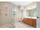 Bright bathroom with glass door shower, vanity with light wood cabinets, and large window at 1404 Churchill Downs Dr, Waxhaw, NC 28173