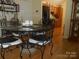 Dining area featuring a glass table with iron chairs, complemented by wood flooring at 158 Margaret Turner Rd, Charlotte, NC 28216